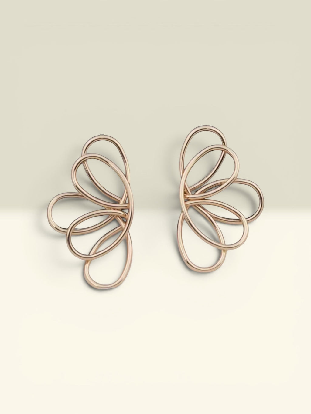 THE GOOD FIND Abstract rose gold-tone metal wire frame earrings with an open-work floral petal design.