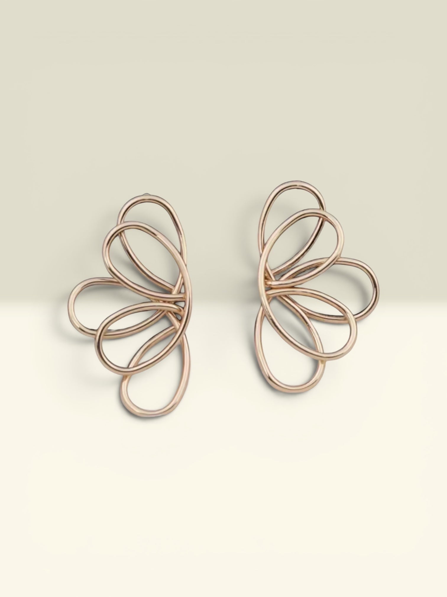 THE GOOD FIND Abstract rose gold-tone metal wire frame earrings with an open-work floral petal design.