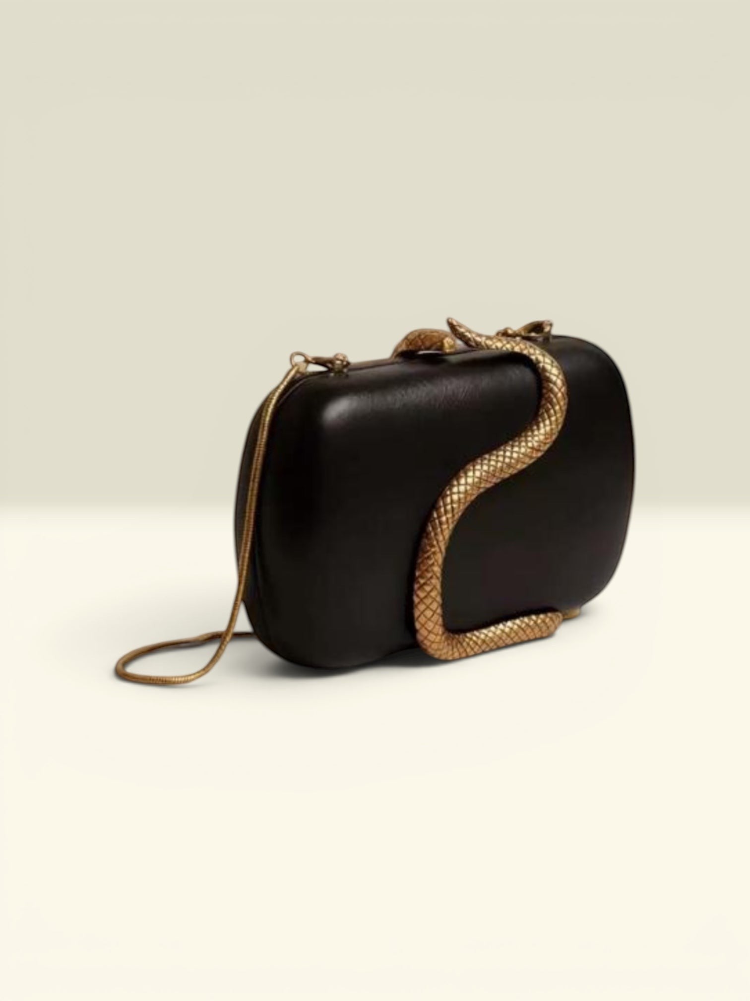 THE GOOD FIND black clutch with gold-tone snake embellishment and chain strap.