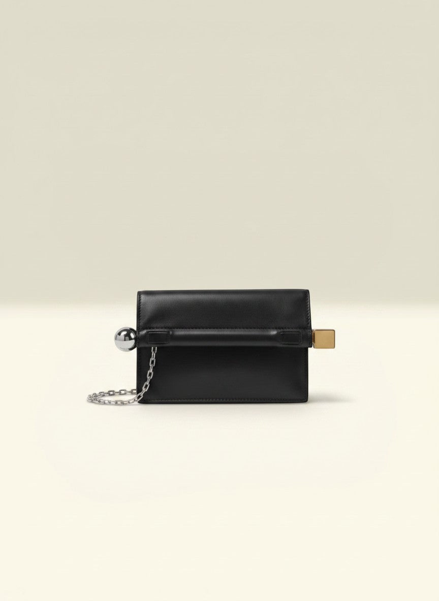 THE GOOD FIND black leather clutch with silver-tone chain strap and metallic clasp. Minimalist design.