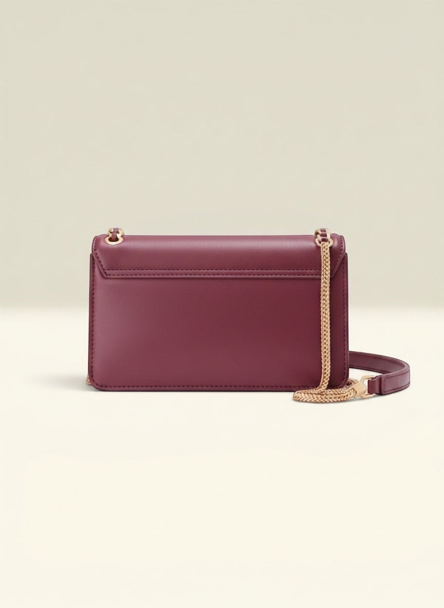 THE GOOD FIND burgundy faux leather shoulder bag with gold-tone chain embellishment and adjustable strap.