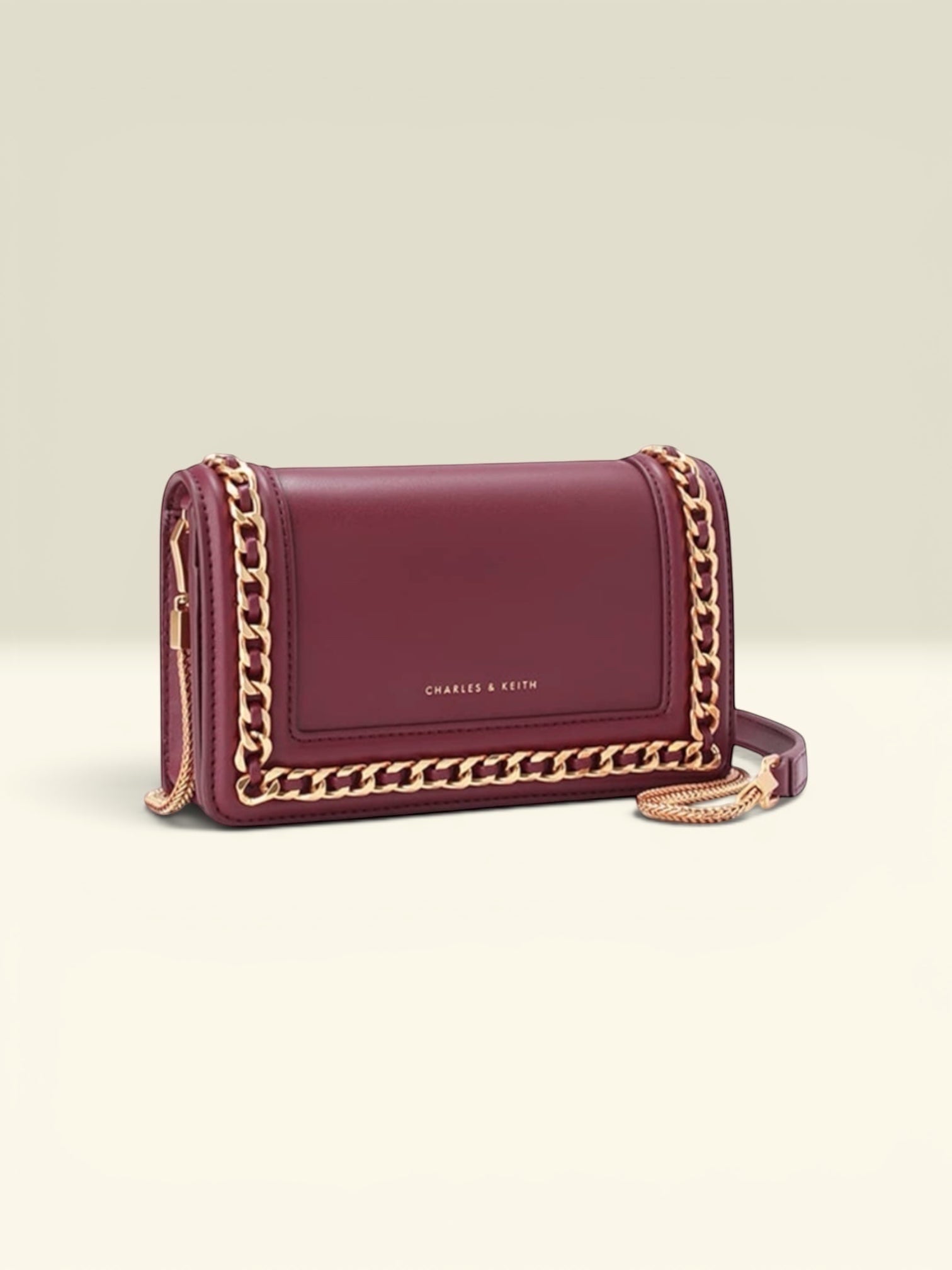 THE GOOD FIND burgundy faux leather shoulder bag with gold-tone chain embellishments and adjustable strap.
