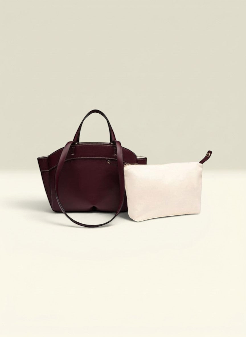 THE GOOD FIND burgundy leather tote bag with matching cream pouch and top handles.