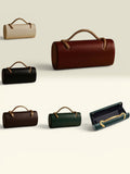 THE GOOD FIND cylindrical top-handle bag in burgundy, black, cream, brown, and green leather with rope handles.