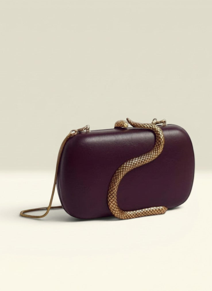 THE GOOD FIND S Embellished Clutch in deep plum with gold-tone snake embellishment and chain strap.