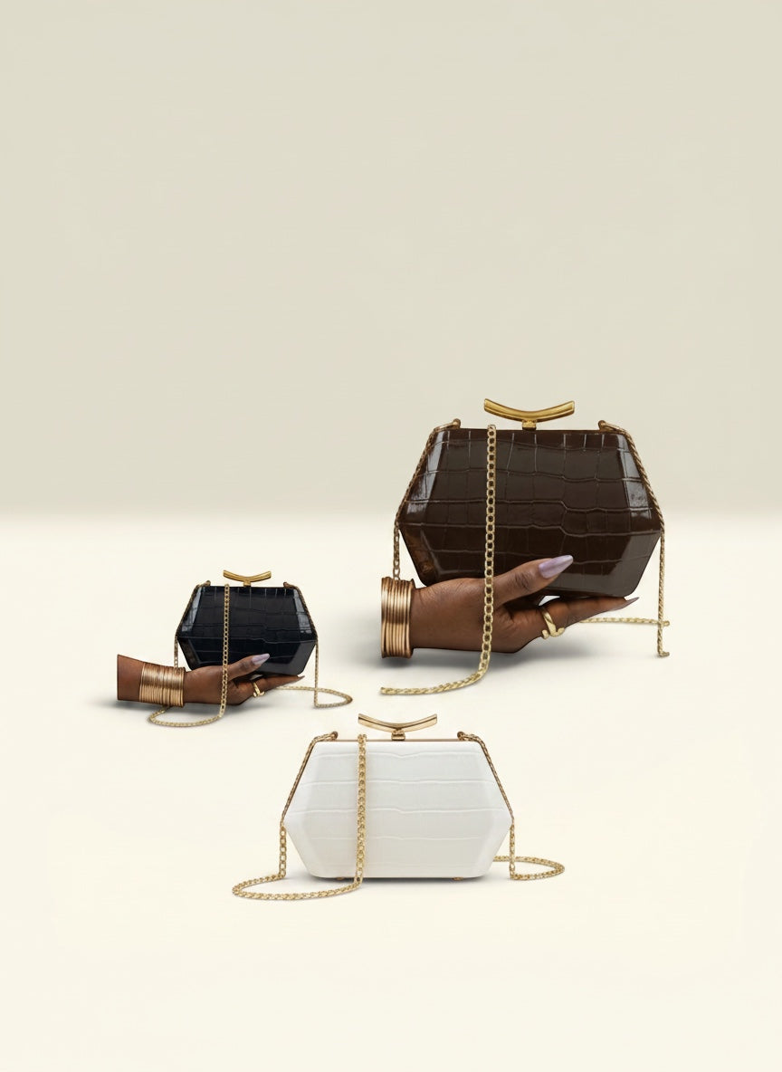 THE GOOD FIND geometric clutch in faux croc leather, available in black, white, and chocolate brown. Features gold-tone chain.