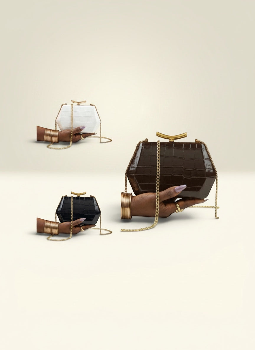 THE GOOD FIND geometric clutch in faux croc leather, available in black, white, and chocolate brown. Features gold-tone chain.