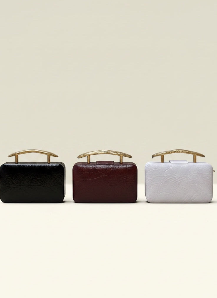 THE GOOD FIND black, burgundy, and white leather clutch purses with gold handles.
