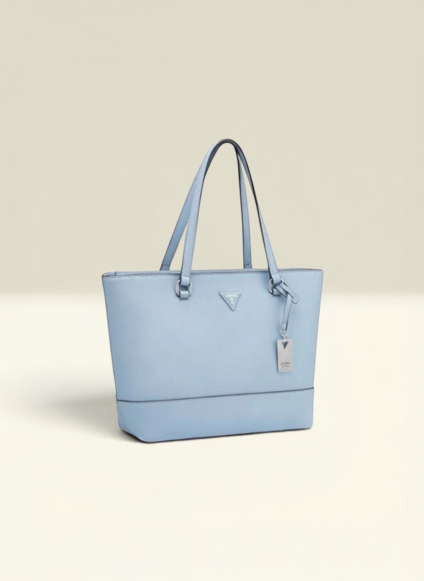 THE GOOD FIND light blue faux leather tote bag with top handles and signature logo charm.